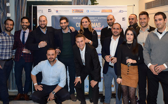 13 members of the Newcastle University Shipping Alumni Society standing and smiling at the camera at a recent event. 